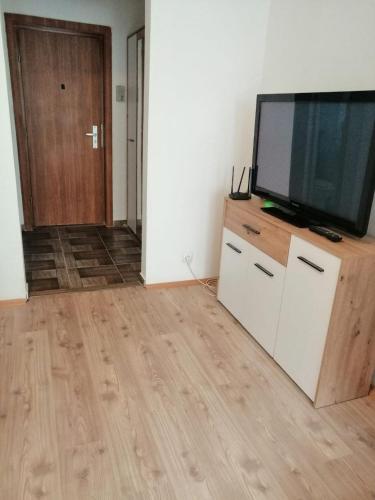 a living room with a flat screen tv on a dresser at Cozy apartment in the heart of the city in Hunedoara