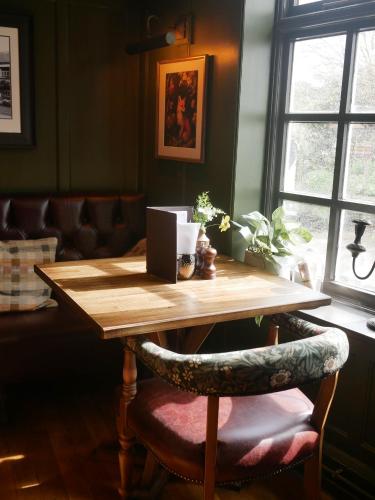 a wooden table in a room with a chair at Queens Head Inn & Restaurant in Hawkshead