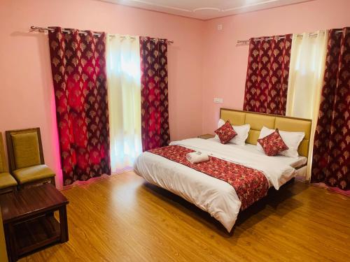 a bedroom with a large bed with red curtains at Faizzy's residency in Srinagar