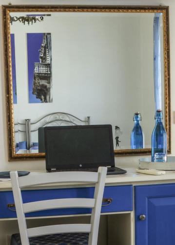 a desk with a laptop computer on a table with a mirror at B&B La Porta D'Oriente in Martano