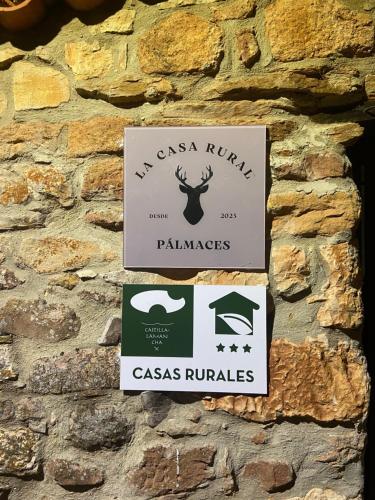 Pálmaces de Jadraque的住宿－La Casa Rural de Pálmaces，石墙边的标志