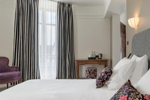 a hotel room with a bed and a window at Hôtel de la Poste in Beaune