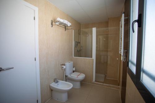 a bathroom with a toilet and a shower and a sink at Hotel LB Villa De Cuenca in Cuenca