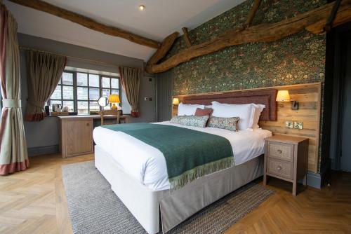 1 dormitorio con 1 cama grande y pared verde en Queens Head Inn & Restaurant, en Hawkshead
