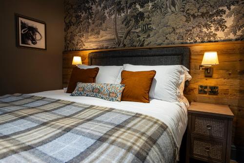 a bedroom with a bed with a blanket and pillows at Queens Head Inn & Restaurant in Hawkshead