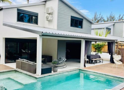 une maison avec une piscine devant une maison dans l'établissement Villa JoCeline - 4ch-4sdb - piscine chauffée - proche plage, à Saint-Paul
