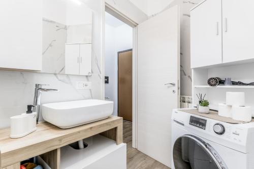 a white bathroom with a washing machine and a sink at Flyaway Retreat - Ciampino Apartment 15 min To Rome in Ciampino
