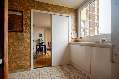 un couloir avec une porte menant à une salle à manger dans l'établissement Beautiful quiet apartment with views of Paris, à Saint-Denis