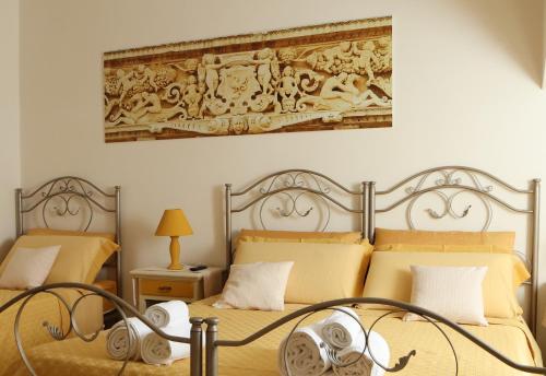 a bedroom with two beds and a painting on the wall at B&B La Porta D'Oriente in Martano