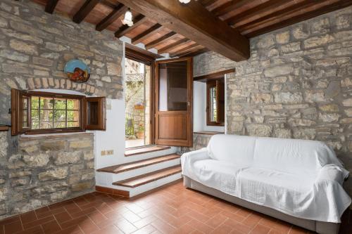 a living room with a white couch in a stone wall at La Petrosa in Radda in Chianti