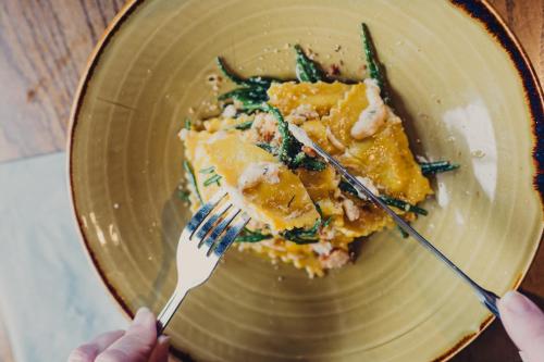 a person holding a plate of food with a fork at Queens Head Inn & Restaurant in Hawkshead