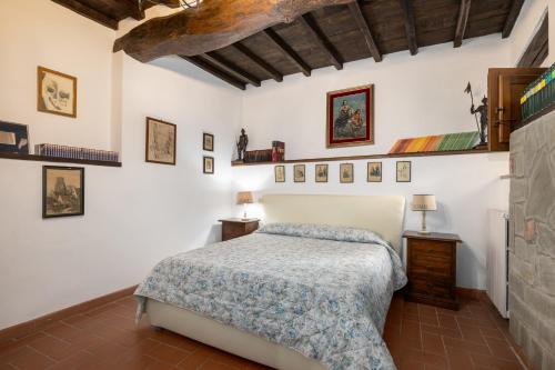 a bedroom with a bed and some pictures on the wall at La Petrosa in Radda in Chianti