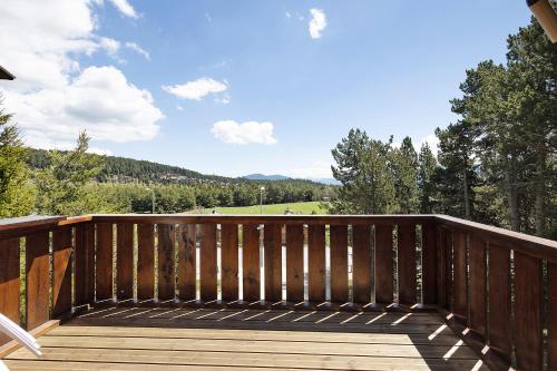 a wooden deck with a view of the mountains at Petit chalet mitoyen Pyrénées 2000 in Font-Romeu