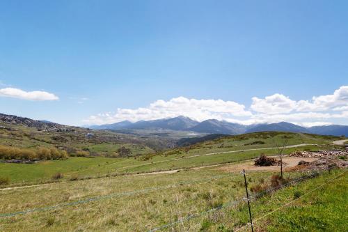 a fence in a field with mountains in the background at Petit chalet mitoyen Pyrénées 2000 in Font-Romeu