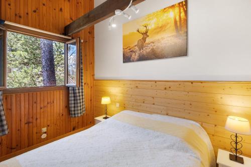 een slaapkamer met een bed en een foto van een hert bij Petit chalet à Pyrénées 2000 in Font-Romeu