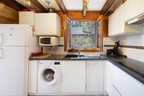 a kitchen with a washing machine and a sink at Petit chalet mitoyen Pyrénées 2000 in Font-Romeu