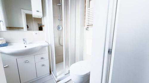 a bathroom with a shower and a toilet and a sink at Alice by Ca-Sa Check in Chioggia