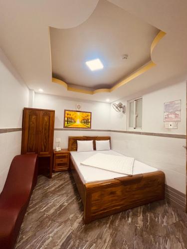 um quarto com uma cama e uma cadeira em Khách sạn THUỲ DƯƠNG 1 em Cidade de Ho Chi Minh
