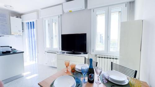 a dining room with a table and a television at Alice by Ca-Sa Check in Chioggia