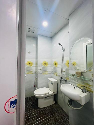 uma casa de banho com um WC, um lavatório e um espelho. em Khách sạn THUỲ DƯƠNG 1 em Cidade de Ho Chi Minh