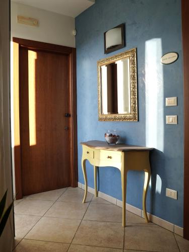 a room with a table and a mirror on a blue wall at B&B La Porta D'Oriente in Martano
