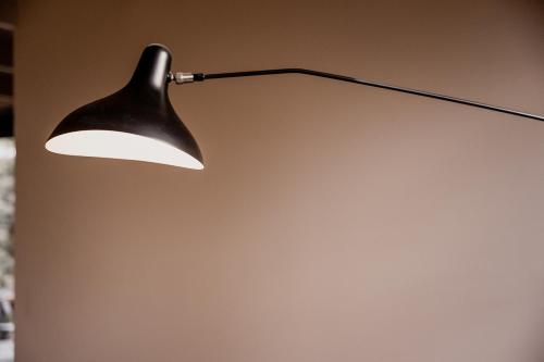 a black lamp hanging on a wall at 'Sisters' - Cliff top cabin with hot tub in Spring Beach