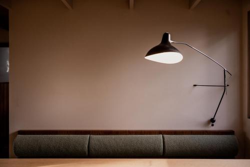 a lamp sitting on a wall next to a couch at 'Sisters' - Cliff top cabin with hot tub in Spring Beach