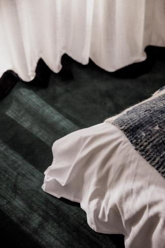 a white dress laying on the floor next to a bed at 'Sisters' - Cliff top cabin with hot tub in Spring Beach