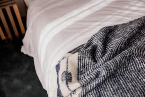 a blanket sitting on top of a bed at 'Sisters' - Cliff top cabin with hot tub in Spring Beach