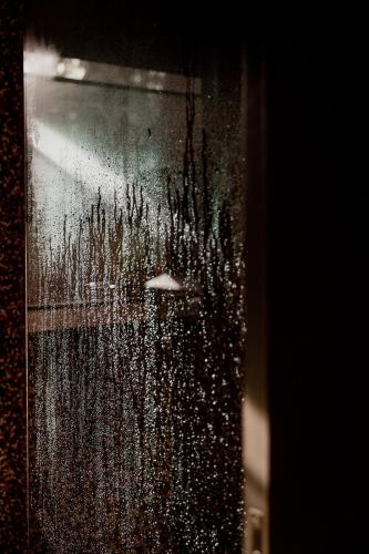 a view of a city through a window with an umbrella at 'Sisters' - Cliff top cabin with hot tub in Spring Beach