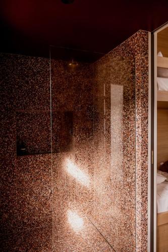 a shower with a glass door in a room at 'Sisters' - Cliff top cabin with hot tub in Spring Beach