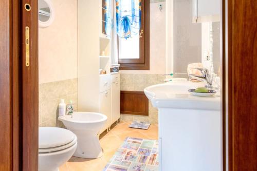 y baño con aseo, lavamanos y aseo. en 5 minuti dal Mare Casa Elegante con AC e WiFi, en Valledoria