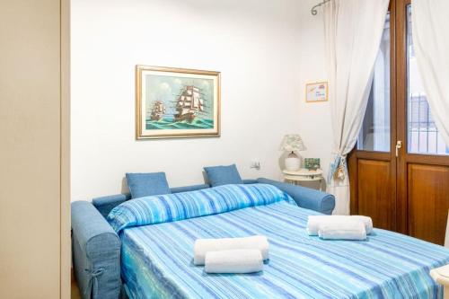 Un dormitorio con una cama azul con dos almohadas blancas. en 5 minuti dal Mare Casa Elegante con AC e WiFi, en Valledoria