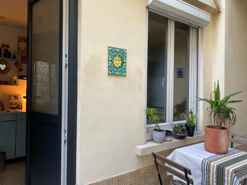 Cette chambre dispose d'une table et d'une fenêtre ornée de plantes. dans l'établissement Charmant studio avec extérieur Paris 13, à Paris