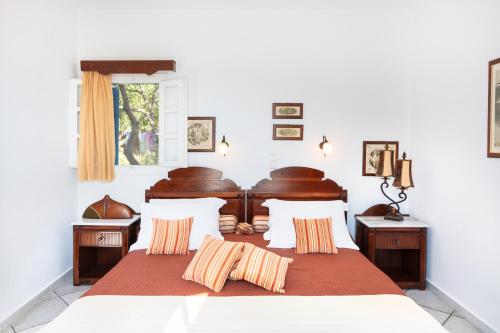 En eller flere senge i et værelse på Sunrock Suites - Villa Pansy