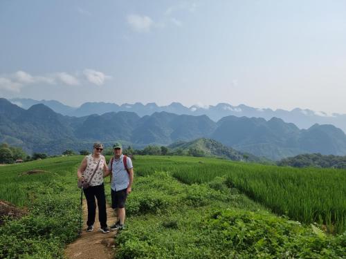 two people walking on a dirt trail in a field at Inh La Home Pu Luong in Pu Luong