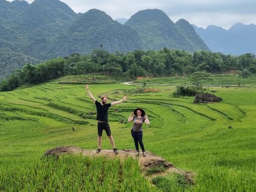 two people standing on a rock in a field at Inh La Home Pu Luong in Pu Luong