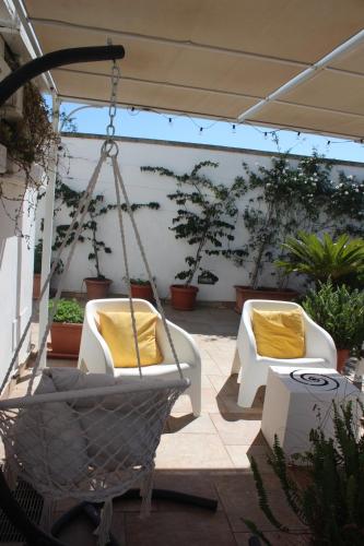 two swinging chairs with yellow pillows on a patio at B&B La Porta D'Oriente in Martano