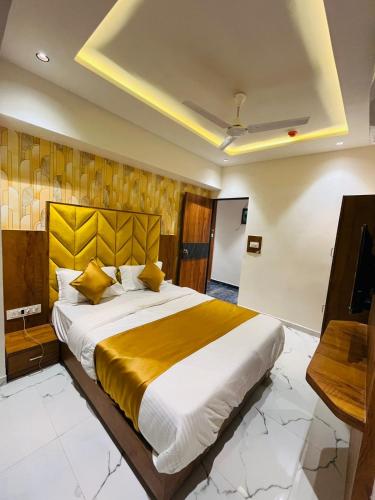 a bedroom with a large bed and a television at Hotel Paramount Villa in Gandhinagar