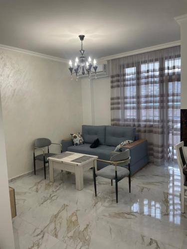 Apartment in centre of Yerevan في يريفان: غرفة معيشة مع أريكة زرقاء وطاولة