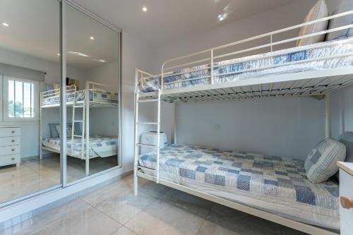 Un dormitorio con dos literas y un espejo. en Villa María, en La Cala de Mijas