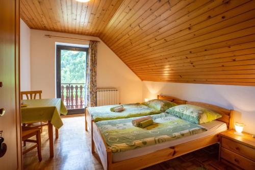 a bedroom with a large bed with a wooden ceiling at Apartments and rooms Kravanja in Trenta