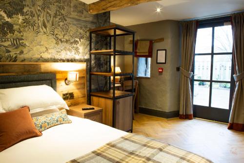 a bedroom with a bed and a book shelf at Queens Head Inn & Restaurant in Hawkshead