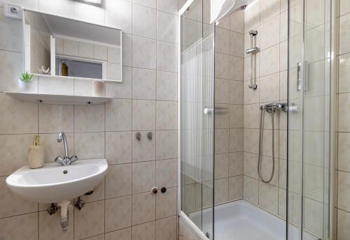 een badkamer met een wastafel en een douche bij Hagyma Panzió in Makó