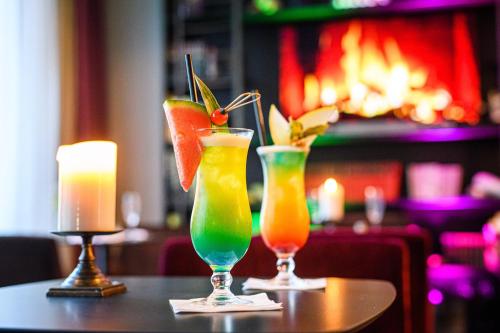 two cocktails sitting on top of a table with candles at Holiday Inn Lübeck by IHG in Lübeck