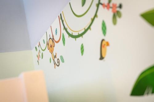 a wall with a garland of leaves and bananas on it at Holiday Inn Lübeck by IHG in Lübeck