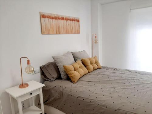 a bed in a white room with a white table at Confortable apartamento en Elche in Elche