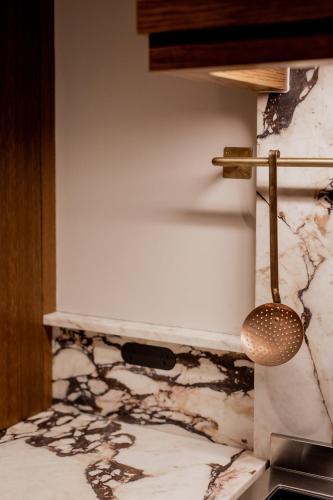 a bathroom with a white marble wall with a strainer at 'Sisters' - Cliff top cabin with hot tub in Spring Beach
