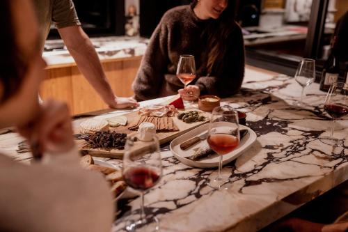 a group of people sitting around a table with wine glasses at 'Sisters' - Cliff top cabin with hot tub in Spring Beach