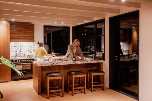 a man standing at a counter in a kitchen at 'Sisters' - Cliff top cabin with hot tub in Spring Beach
